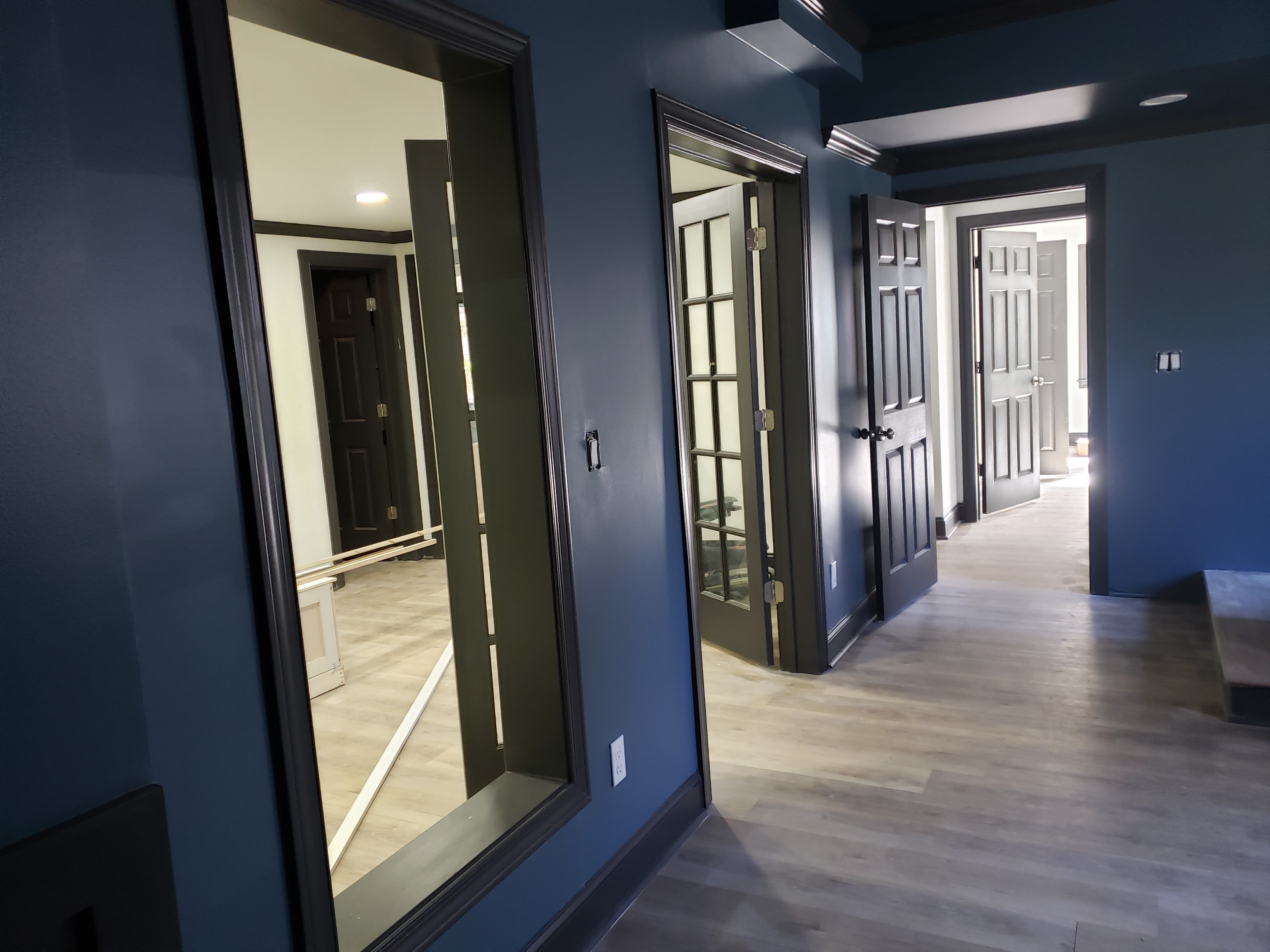Stairwell with navy walls and black painted trim — pre-feature-wall