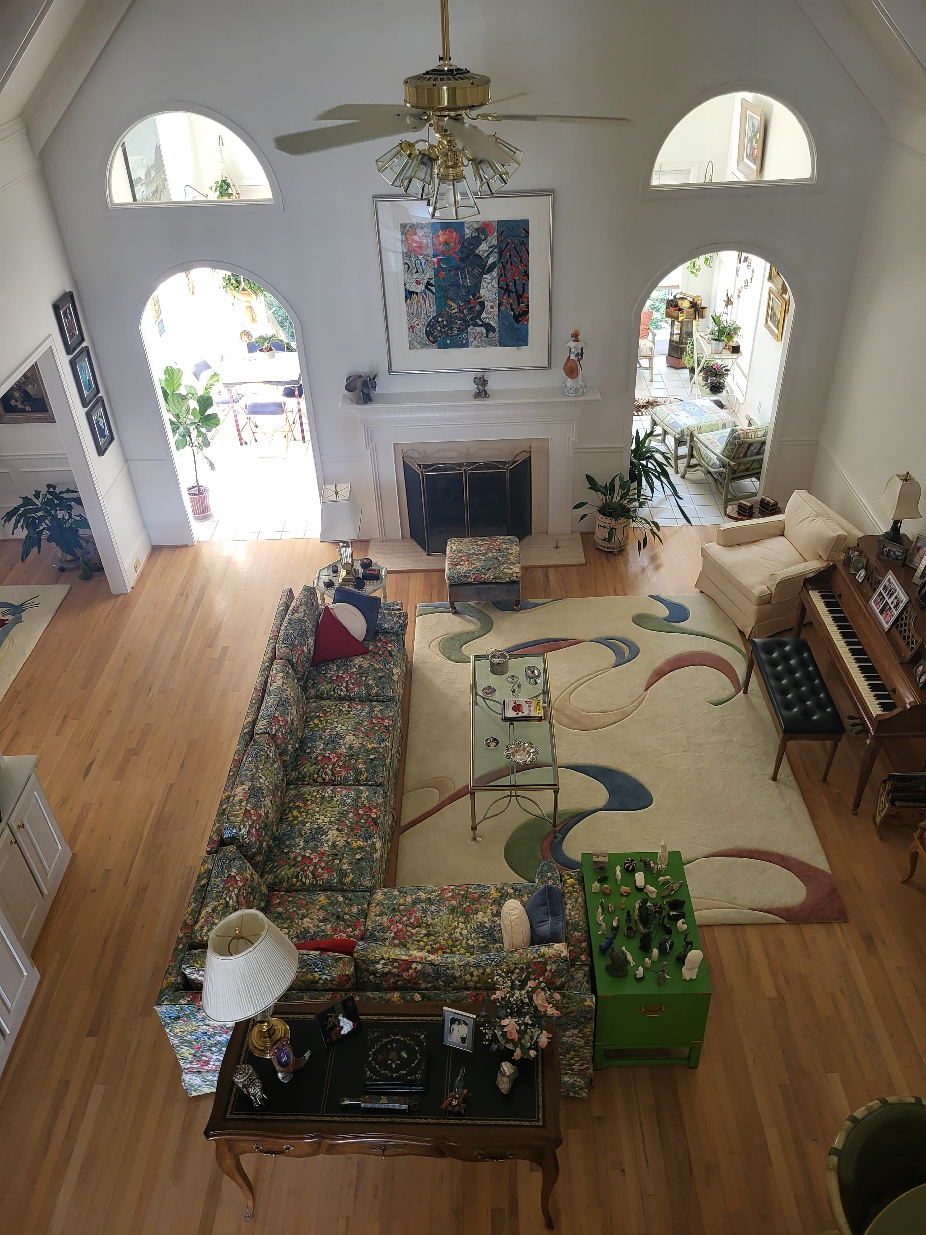 Dated living room with painted-on mural accent wall and floral upholstery — before